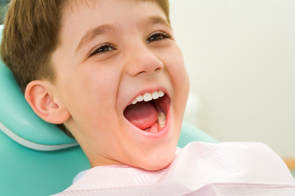 little boy with mouth open for dental exam